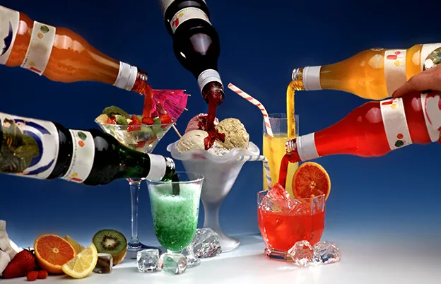 colorful syrup bottles pouring into drinks